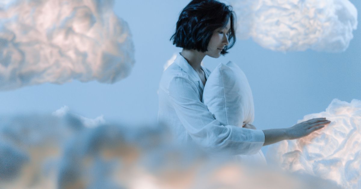 A serene scene of an Asian woman dreaming among soft, ethereal clouds.